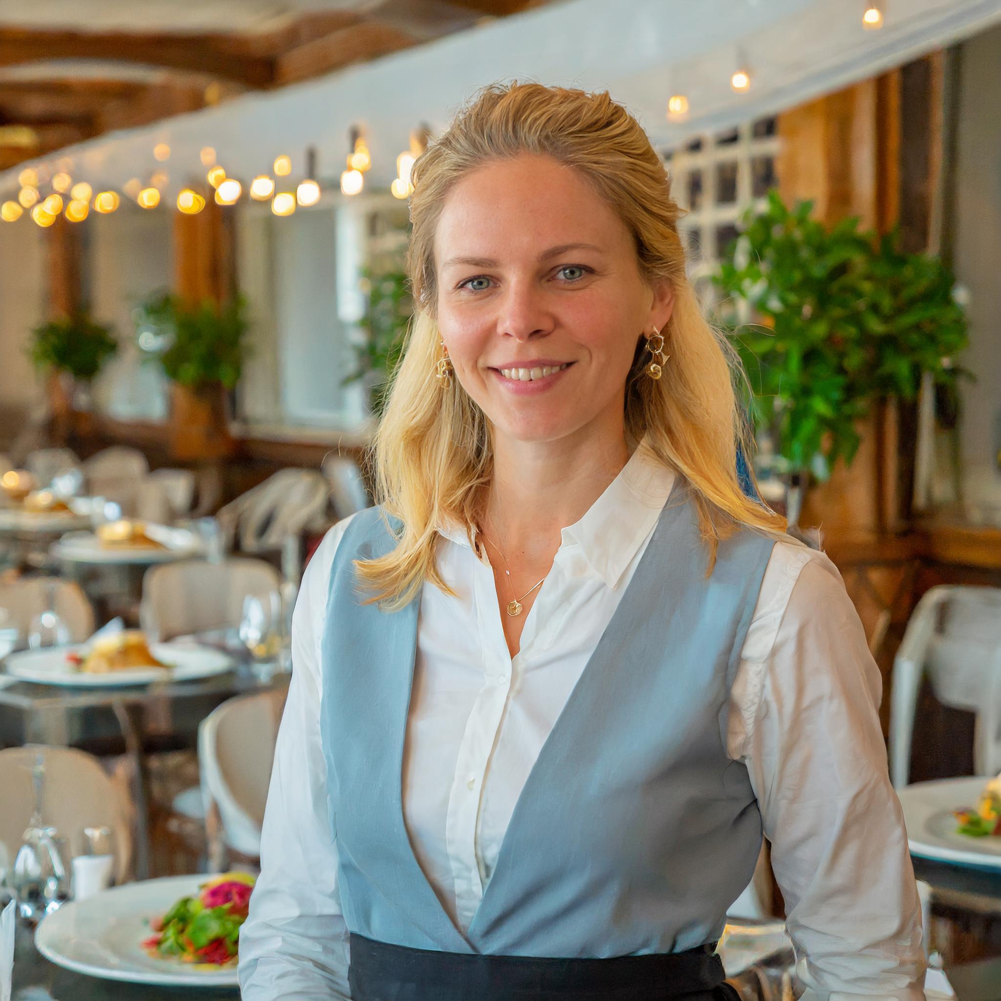 Teammitglied, das mit einem Kunden am Tisch sitzt und lächelt