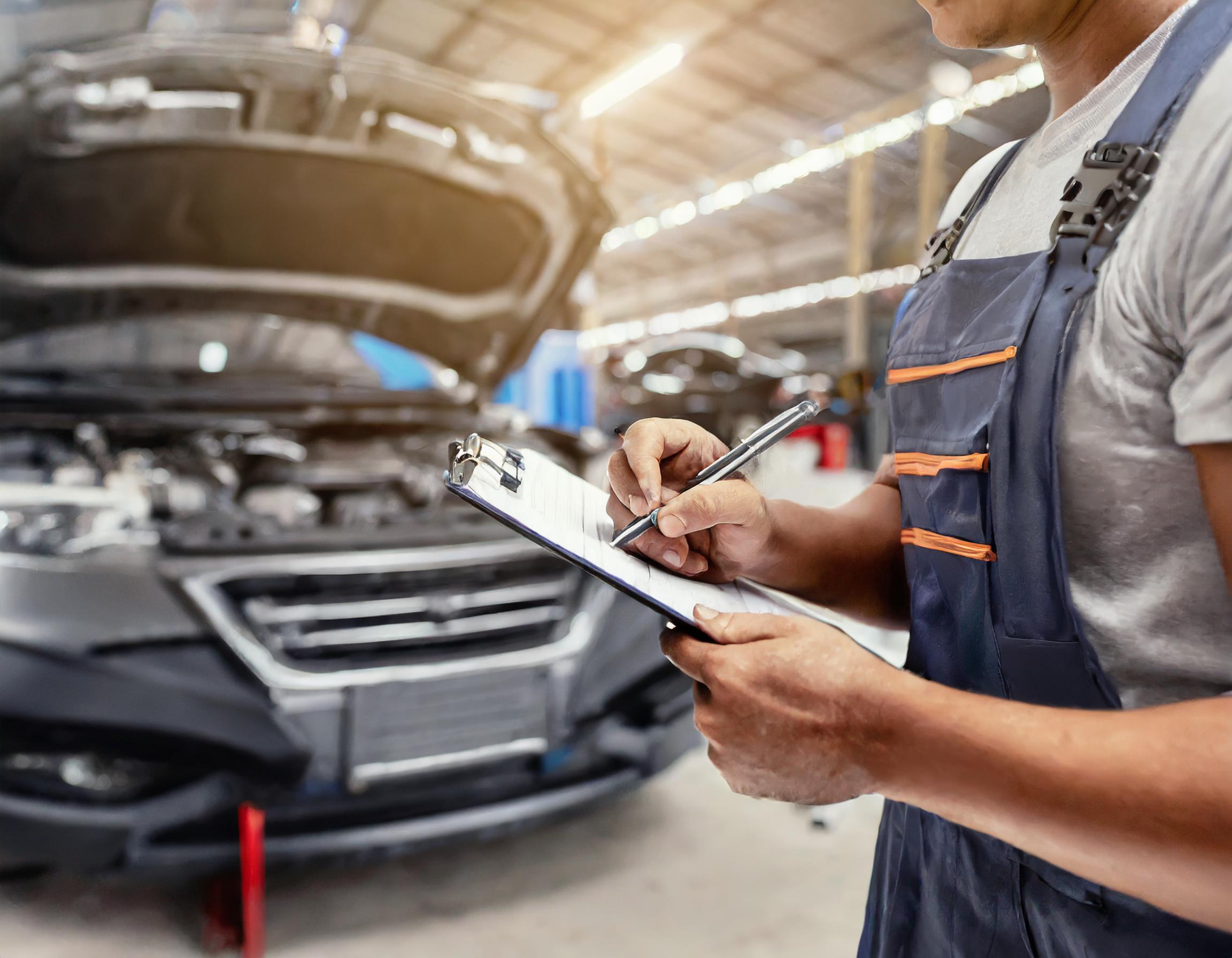 Verkäufer, der den Kunden beim Ausfüllen der Fahrzeugverkaufsunterlagen unterstützt